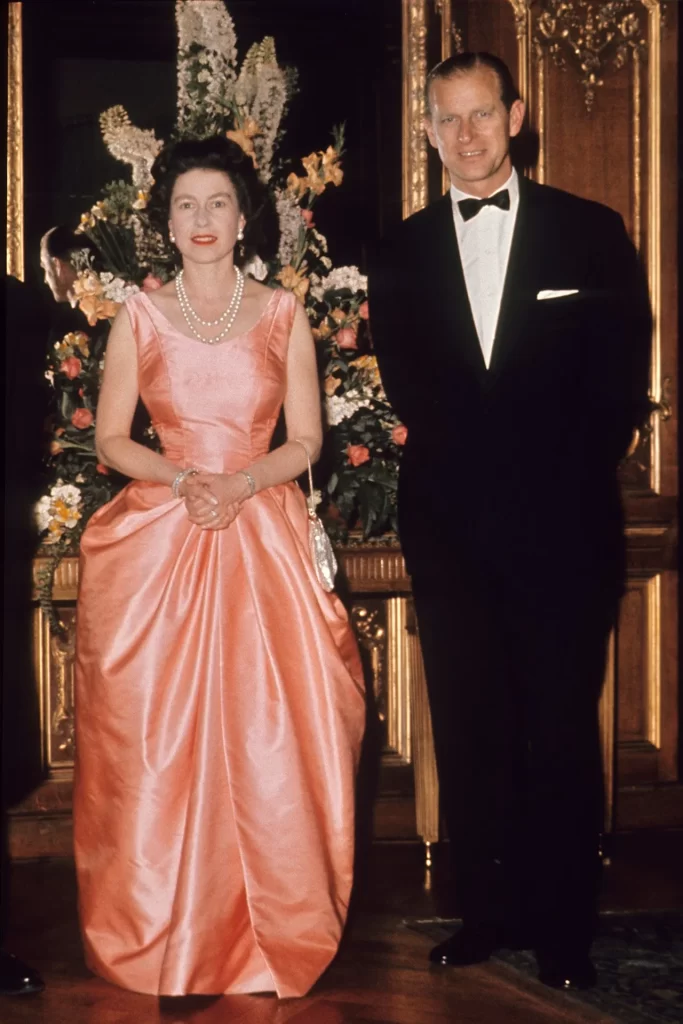 June 1963 The Queen wore a coral evening gown with her signature pearls to attend an event in London with the Duke of Edinburgh.